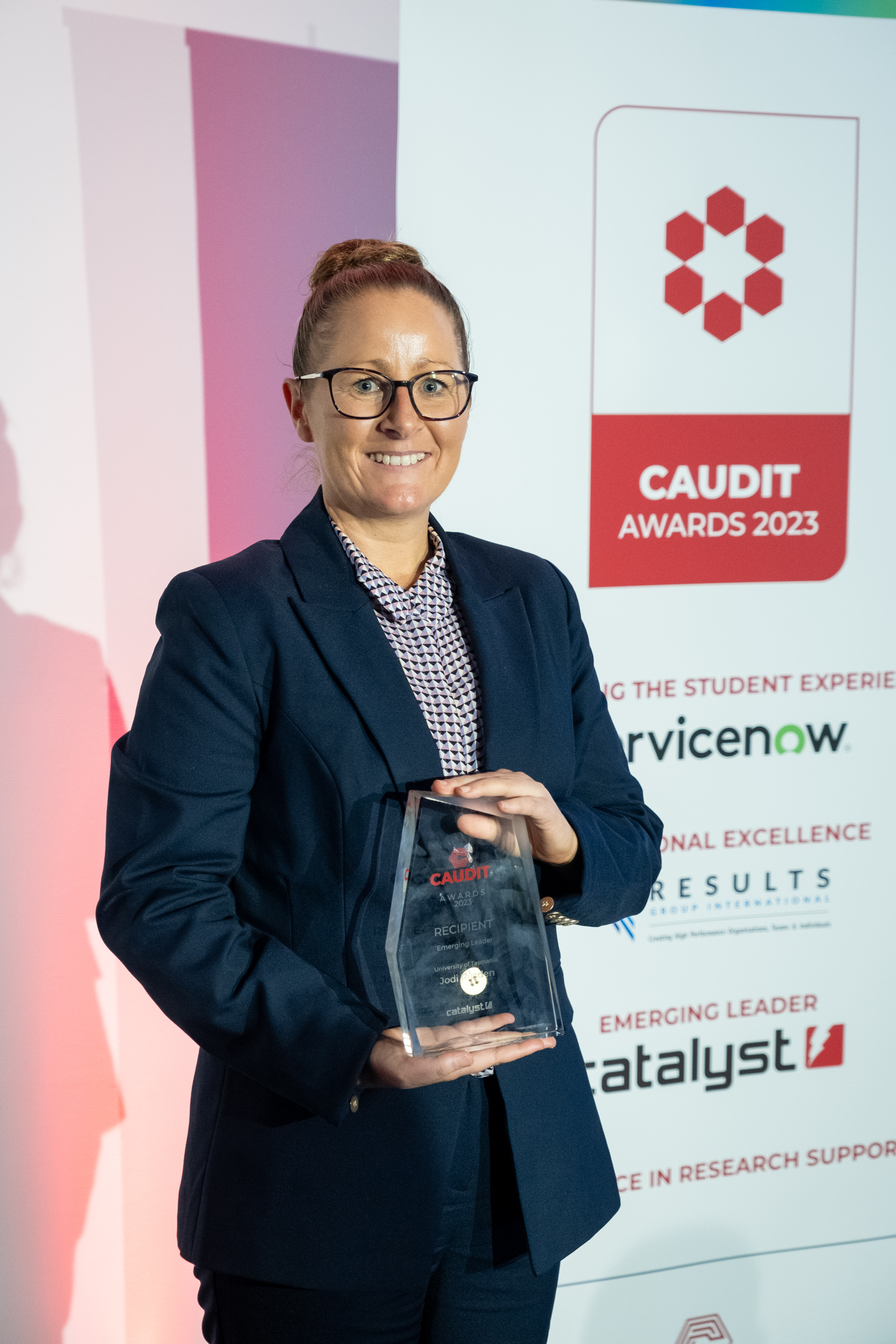 Picture of Jodi Rusden holding CAUDIT Award Trophy