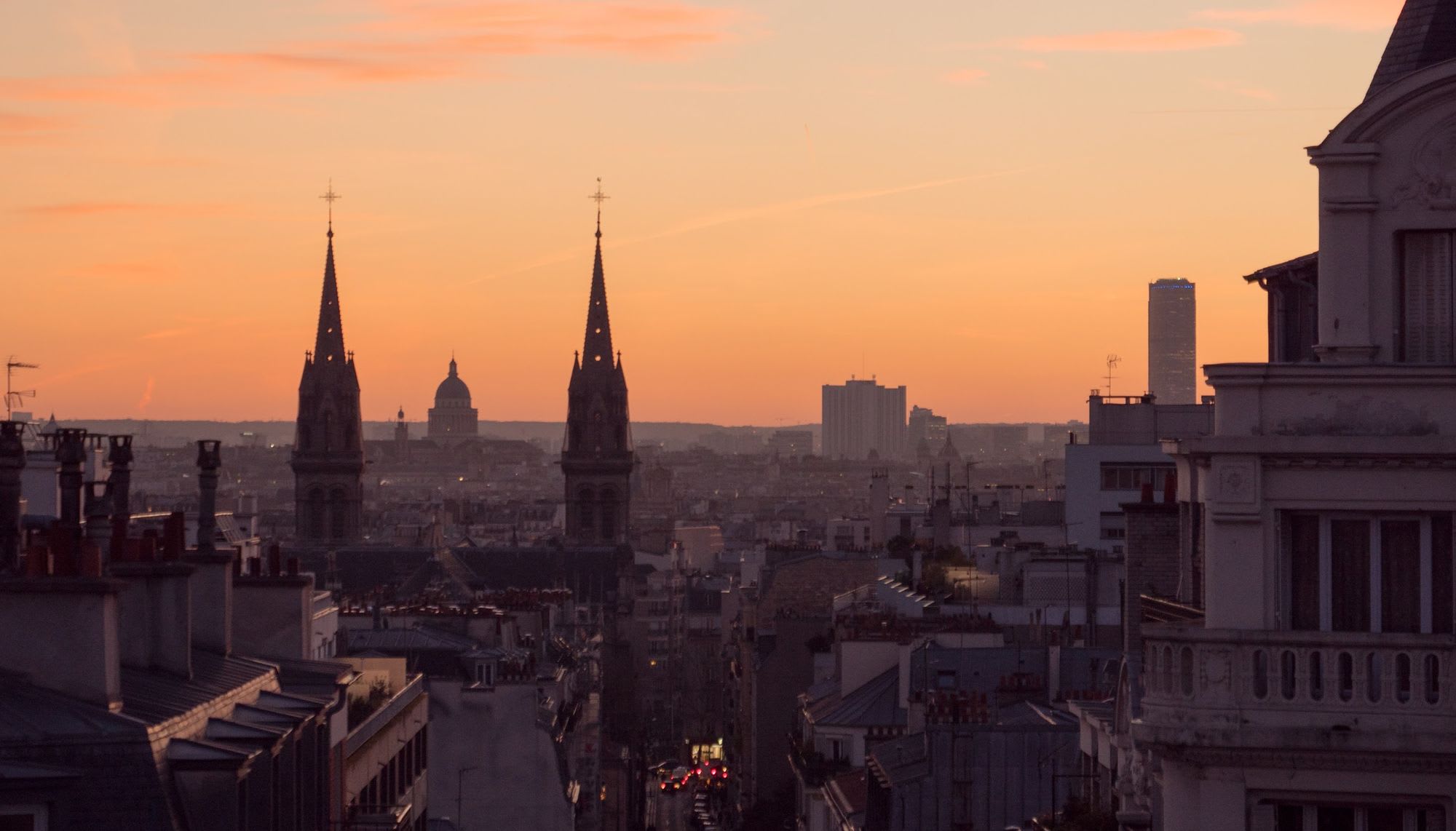 Photo of a church, the Pantheon et Montparnasse shot over the roofs of Paris at Sunset