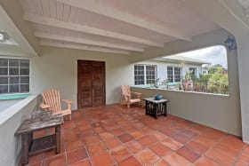 Covered front patio with a unique front door