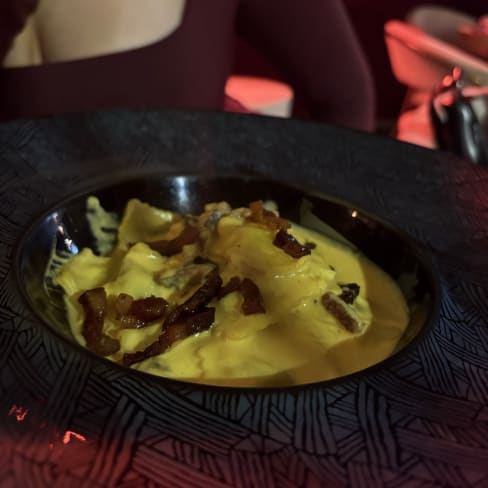 Base cremosa con salsa ricca, guarnita con croccante bacon, per un piatto confortevole e indulgente.