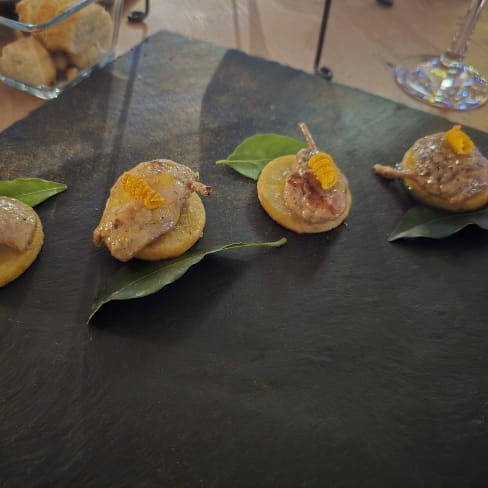 Selezione di quattro eleganti antipasti a base di polenta, con pâté cremoso e guarnizione di scorza di agrumi.
