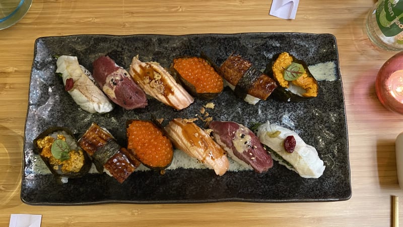 Nigiri van zeebaars, munt en goji bes. Ossehaas met sesamolie. Geflambeerde zalm met miso dressing, zalmeitjes, paling met palingsaus, zee-egel. - Yuki Sushi, Leiden