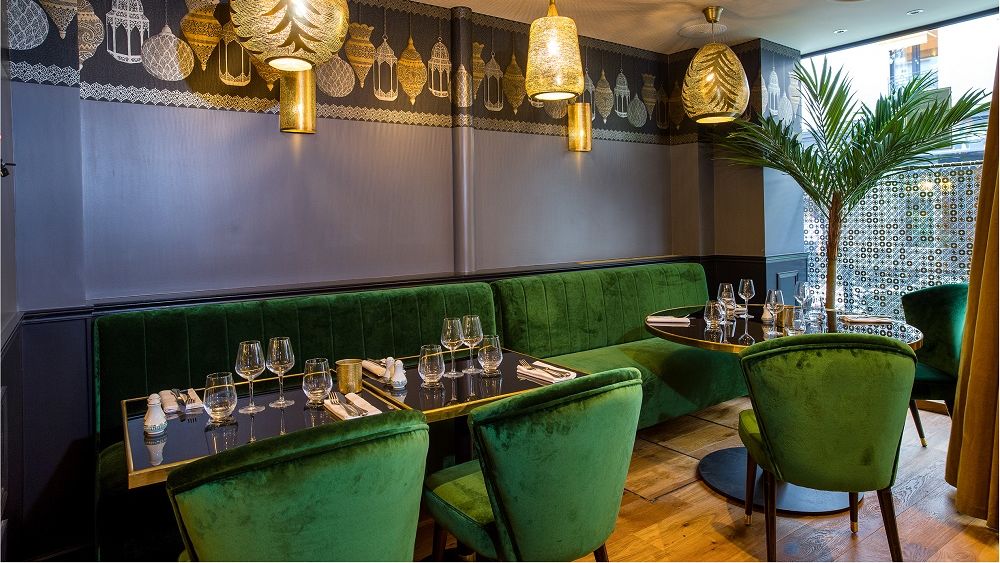 Salle du restaurant Figuig, banquettes vertes et luminaires chaleureux