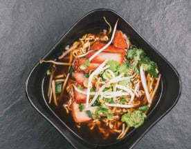 Kom met dampende noedelsoep met malse char siu varkensvlees, verse taugé, fijngesneden lente-ui en koriander, geserveerd in een rijke, hartige bouillon.