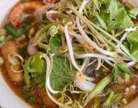 Bol de soupe de nouilles avec un bouillon savoureux, garni d'herbes fraîches, de pousses de soja croquantes, d'oignons verts et de crevettes, accompagné de nouilles de riz tendres.