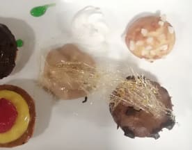 Assortiment de petits desserts comprenant une pâtisserie au chocolat, une crème pâtissière jaune avec une cerise, une garniture crémeuse aux noix avec des amandes, et un dessert surmonté de crème fouettée, offrant une variété de textures et de saveurs.