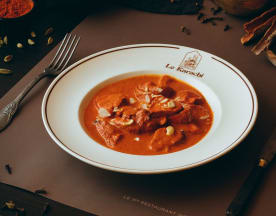 Plat copieux de ragoût de bœuf avec des morceaux de viande tendres dans une sauce rouge profonde, parfumée aux épices et garnie de coriandre hachée.