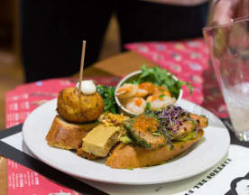 Salmón sazonado con hierbas, acompañado de croqueta de papa, ensalada de hojas frescas y camarones.
