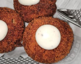 Croquetas doradas y crujientes, rellenas de una mezcla sabrosa, acompañadas de una suave salsa aioli.