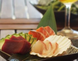 Sashimi variado com fatias de atum vermelho, salmão rosa e peixe branco, acompanhado de fatias de pepino e uma concha de vieira.
