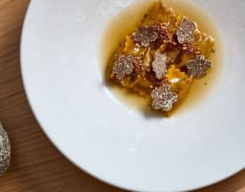 Ravioli filled with a rich, creamy filling, topped with thinly sliced truffles and served in a light, savory broth.