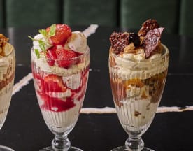 Three distinct parfaits: the left features creamy vanilla layers with caramelized pieces and fruit; the middle contains fresh strawberries with smooth cream and red fruit sauce; the right combines rich chocolate with brownie pieces and nut or chocolate shavings.