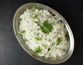 Arroz branco fofo, guarnecido com folhas de coentros frescos, bem cozido e com um leve brilho.