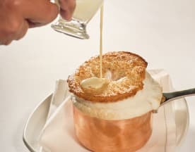 Soufflé bem assado com uma cobertura dourada e arejada, servido com um molho cremoso que realça a sua aparência indulgente.