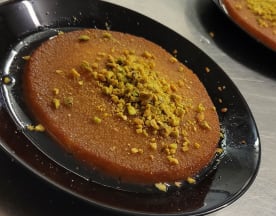 Dessert sucré à base de semoule, garni de pistaches finement hachées, offrant une texture croquante et une saveur de noix.