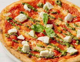 Klassieke pizza met een dunne, gouden korst, rijk tomatensaus, romige mozzarella, basilicum pesto en verse tomaatblokjes, afgewerkt met een basilicumblad in het midden.