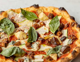 Versgebakken pizza met een dunne, knapperige korst en een licht geroosterde rand, belegd met rijke tomatensaus, perenschijfjes en blokjes blauwaderkaas. Ruime hoeveelheden gebakken champignons versterken de aardse smaken, terwijl verse basilicumblaadjes zorgen voor een vleugje groen en aromatische frisheid.