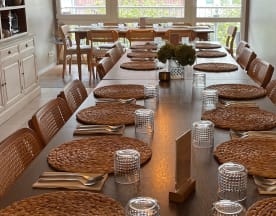 Geräumiger Speisebereich mit einem langen Holztisch, der rustikal und einladend gedeckt ist, ideal für gemeinschaftliche Essensanlässe.