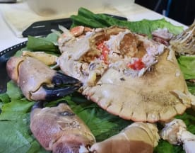 Cangrejo fresco, parcialmente abierto, con carne tierna y jugosa, acompañado de lechuga crujiente.