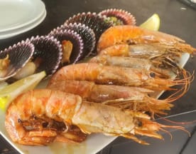 Plato de mariscos con camarones grandes y jugosos, vieiras y rodajas de limón, resaltando la frescura del mar.