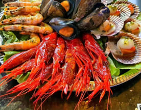 Plato de mariscos lujoso con camarones rojos, langostinos a la parrilla, mejillones y vieiras, todo sobre lechuga fresca.