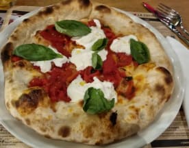 Pizza appena sfornata con crosta morbida e bruciacchiata, salsa di pomodoro ricca, mozzarella cremosa e foglie di basilico fresco.