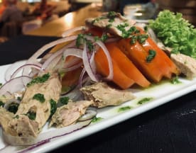 Pollo desmenuzado tierno con tomates frescos, cebolla roja y aderezo de hierbas, acompañado de lechuga crujiente.