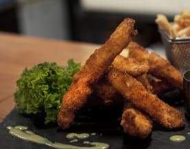 Fritos crujientes de pescado o pollo, acompañados de lechuga fresca y una salsa cremosa para mojar, con papas fritas como guarnición.
