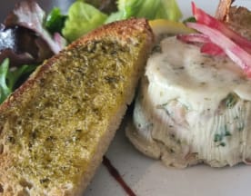 Terrine crémeuse aux herbes, accompagnée d'oignons marinés, de pain grillé avec tartinade d'herbes, d'une sauce crémeuse et d'une salade de jeunes pousses.