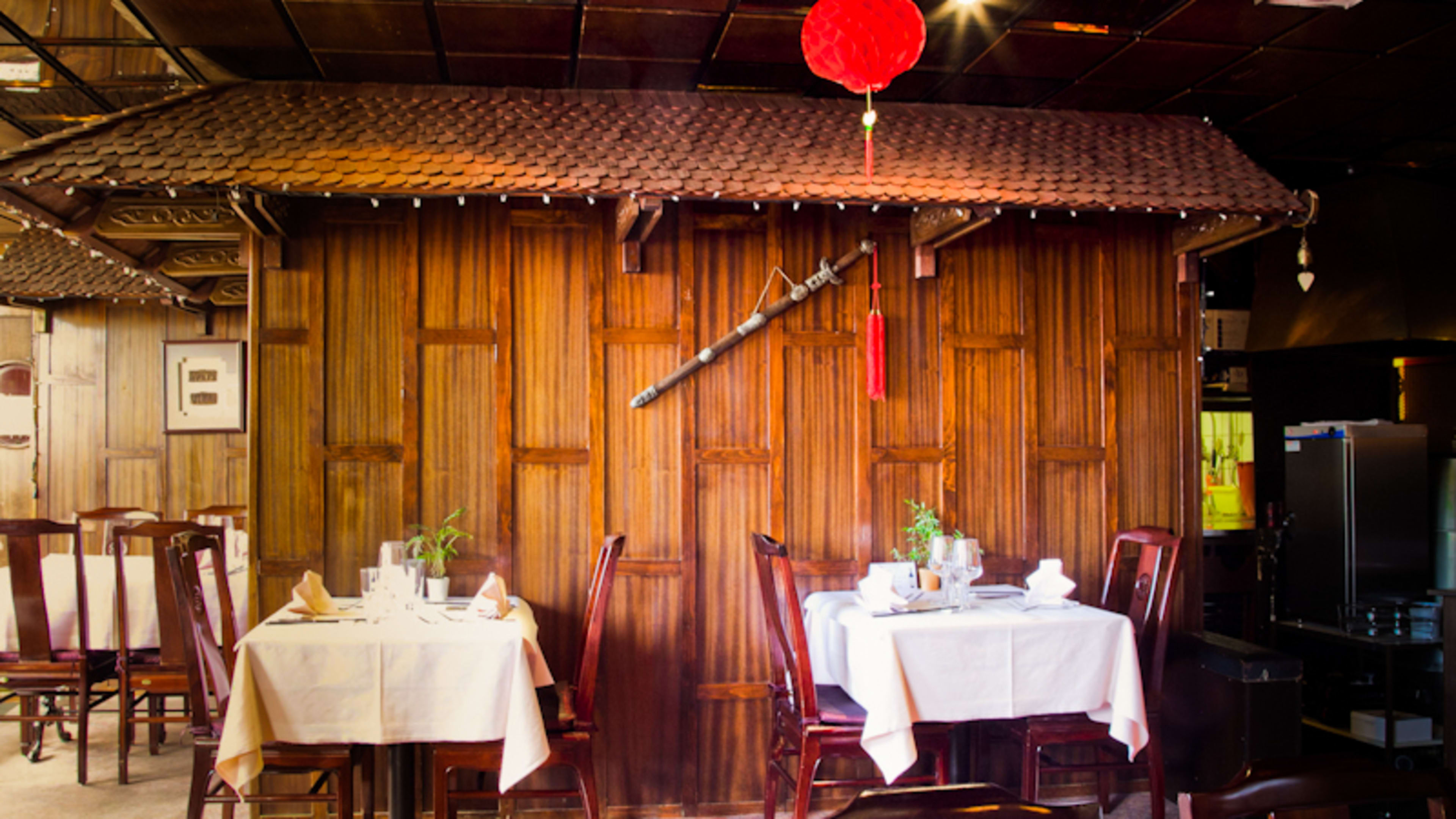 Intérieur de restaurant chaleureux avec des murs en bois, décor rustique et ambiance culturelle unique.