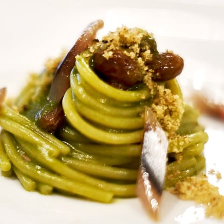 Spaghetti con salsa verde di erbe fresche, acciughe e noci tritate.