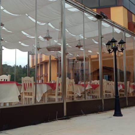 Area esterna del ristorante con patio chiuso, tavoli ben disposti e atmosfera accogliente.