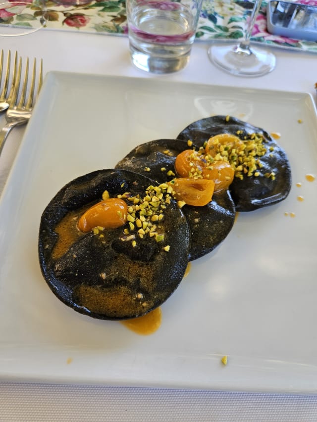 Ravioloni di nostra produzione al nero di seppia, ripieni di astice e ricotta di bufala con datterini gialli e granella di pistacchio - Il Convento di Cuma