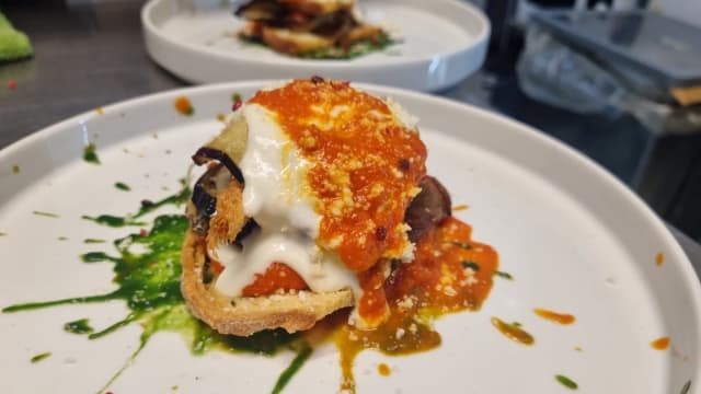 LA NOSTRA PARMIGIANA DI MELANZANE ,CROSTONE DI SEMOLA MELANZANA FRITTA MANTECATA CON BASILICO,FONDUTA DI REGGIANO BRUCIATA AL PEPE ROSA ED ESTRATTO AL DATTERINO - Elios Café, Rome