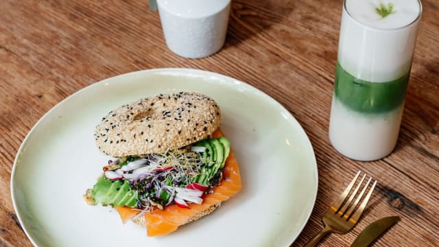 Bagel with sliced avocado, wasabi spread, white cheese, pomegranate - Hug the Tea, The Hague