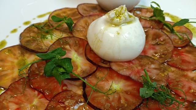 Carpaccio de tomate azul, burrata, albahaca y su aliño especia - Verde Esmeralda