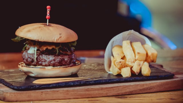 Hamburguesa angus 100% 250 gr, en pan de brioche, queso provolone, manzana asada, rúcula, cebolla caramelizada y mayonesa casera de mostaza miel y cacahuetes - Hotel Roma Reial, Barcelona