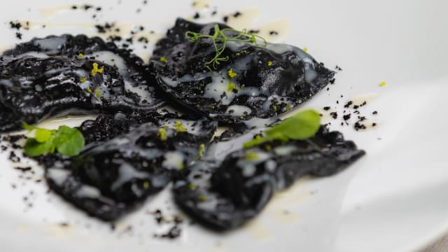 Mezze lune al nero (nostra produzione) ripiene di ragu' di triglia di scoglio, accompagnate da una salsa bianca di mare, polvere di olive nere cotte in forno e scorza di lime - Casa Grazia, Cagliari