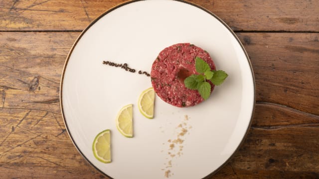 Tartare di scottona battuta al coltello, olio, sale e pepe con fondo bruno di manzo, polvere di peperone rosso e anello di pane - La Dispensa di Pomarance