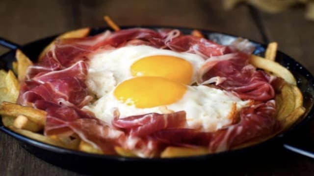 Huevos "rotos" con jamon ibérico y patatas paja - Tapas Les Corts