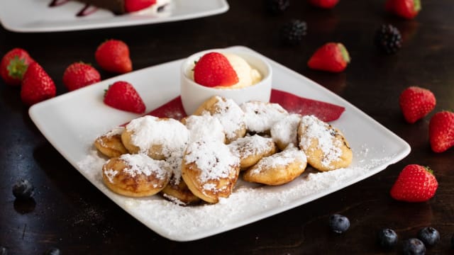 Poffertjes with butter, powdered sugar and vanilla ice cream - De Blauwe Hollander