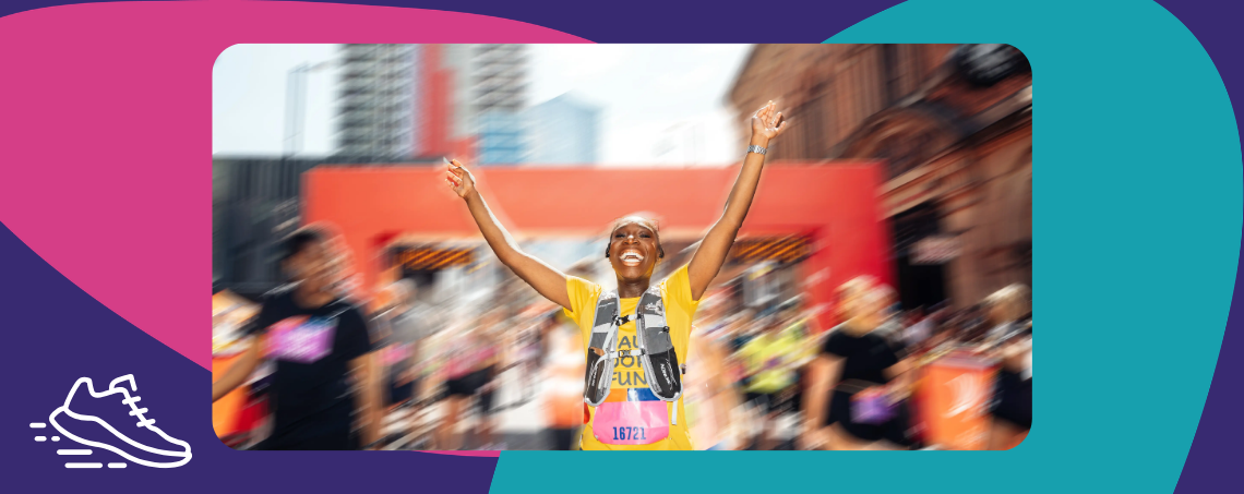 Blurred photo of a runner with their hands in the air celebrating finishing a race