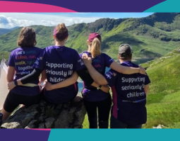Four people with their backs to the camera on a mountain