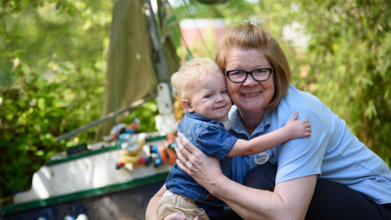 Boy cuddling nurse