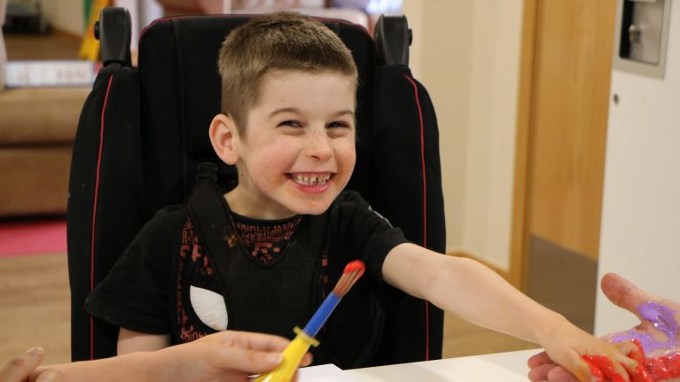 Boy smiling with paintbrush