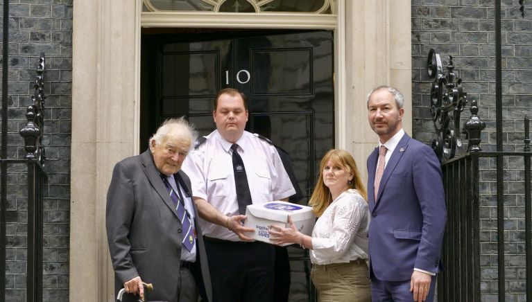 A group of four people are stood in front of Number 10 Downing Street.