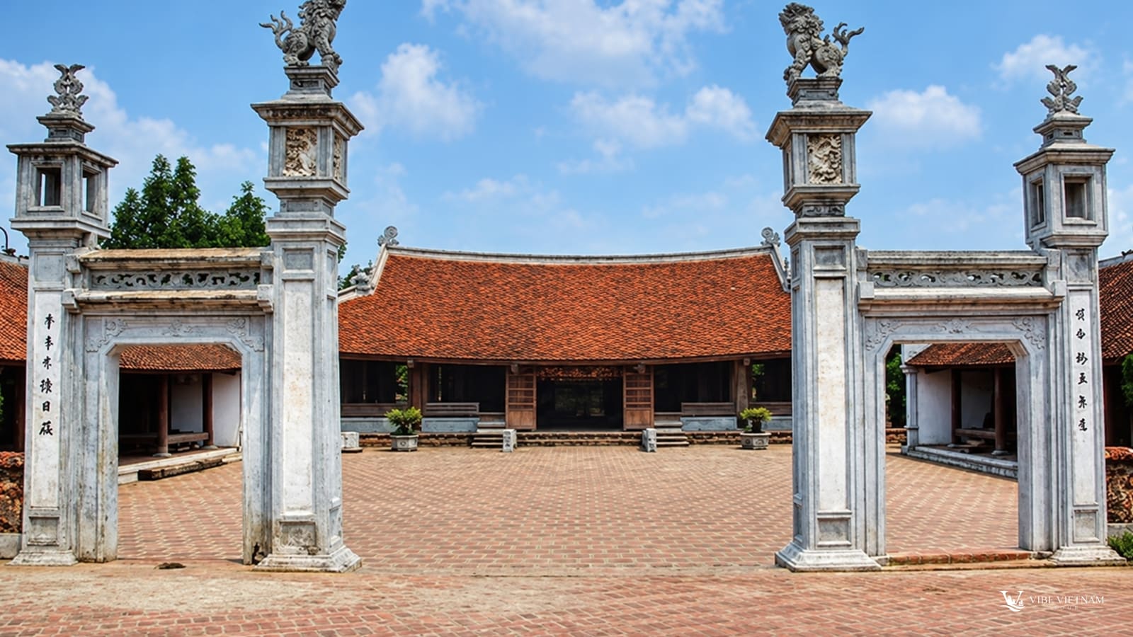 Cổng đình làng cổ Đường Lâm với cột đá chạm trổ và sân gạch đỏ
