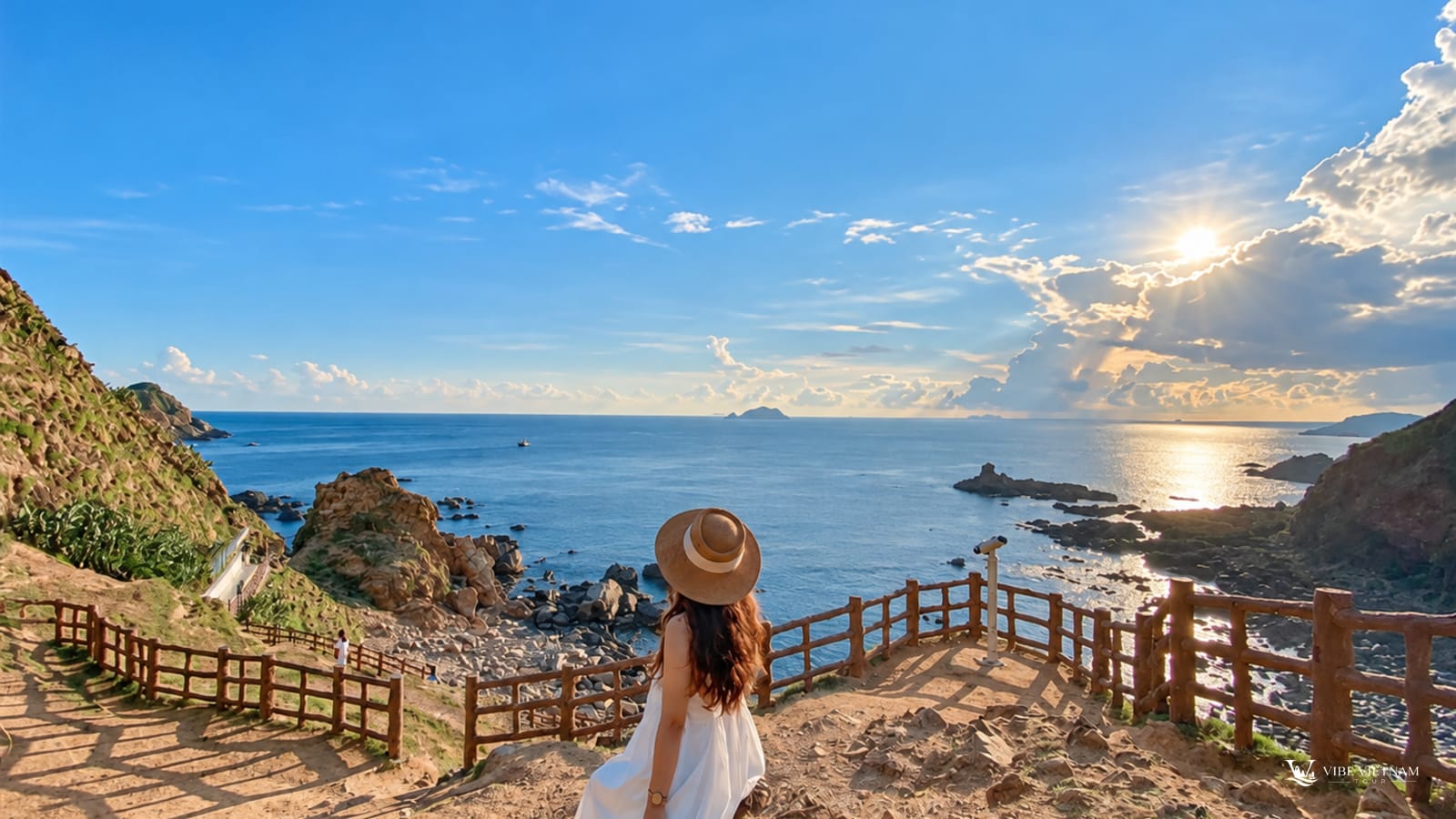 Du khách ngồi trên lan can gỗ ngắm hoàng hôn trên vịnh biển Côn Đảo