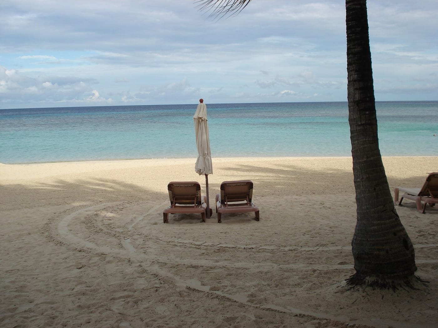 Transats et parasol sur la plage de West Bay à Roatán, Honduras