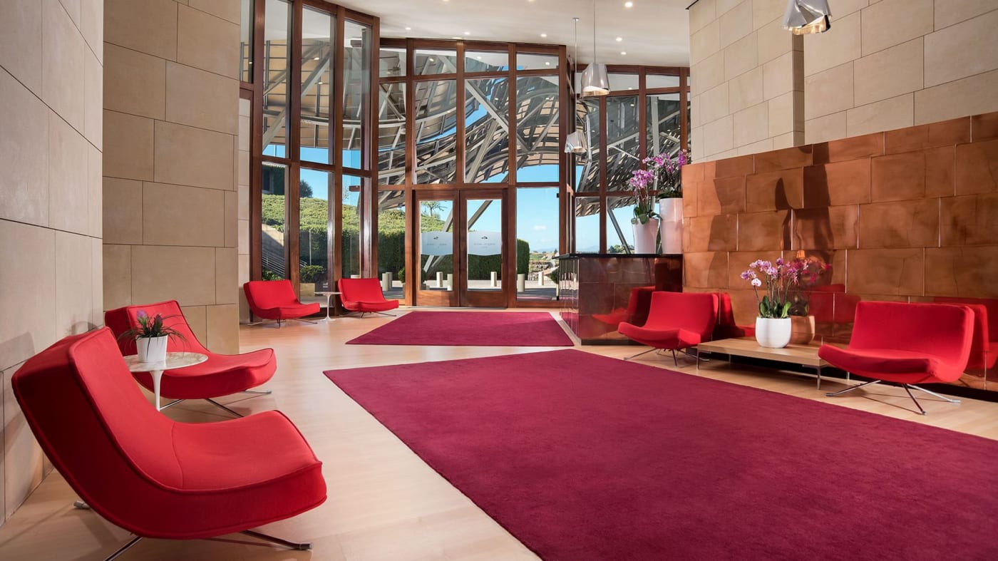 Le hall de l'hôtel Marqués de Riscal, fauteuils rouges et verrière sur les vignes